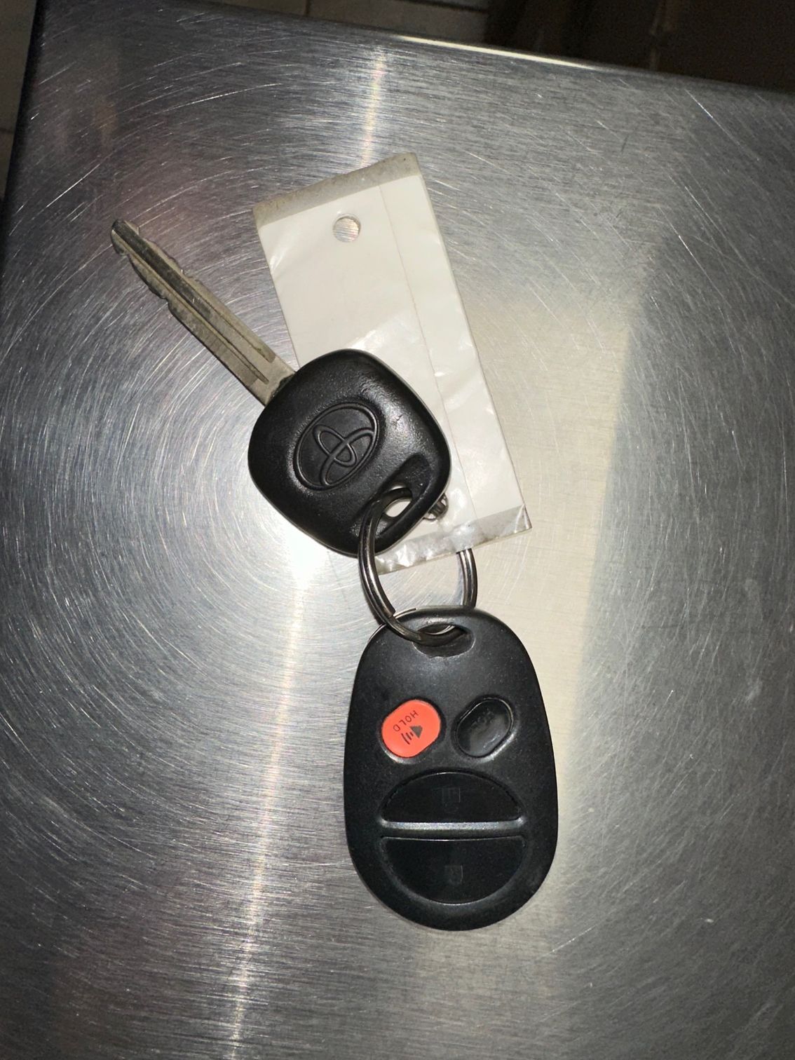 Black Toyota key and fob on stainless steel counter top.