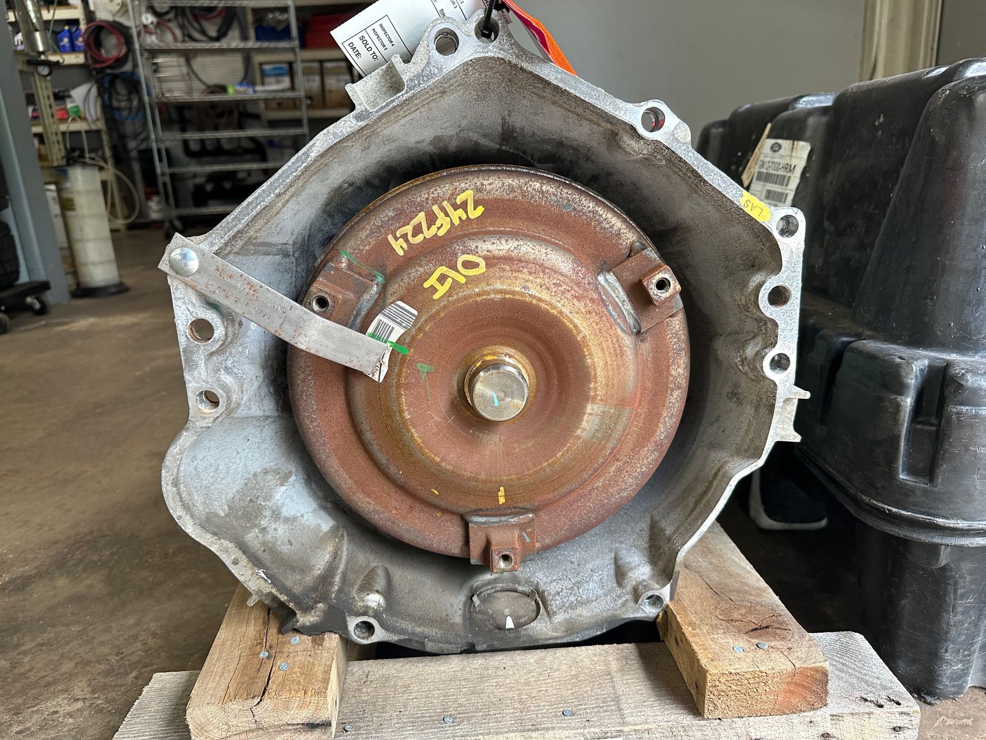 A gearbox is sitting on top of a wooden pallet. | Lou's Car Care Center, Inc.