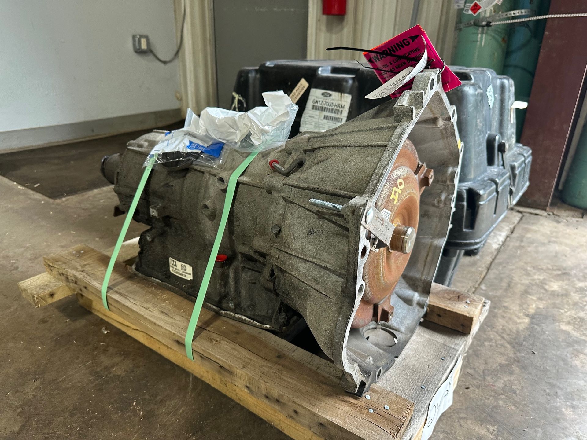 A gearbox is sitting on a wooden pallet in a garage. | Lou's Car Care Center, Inc.