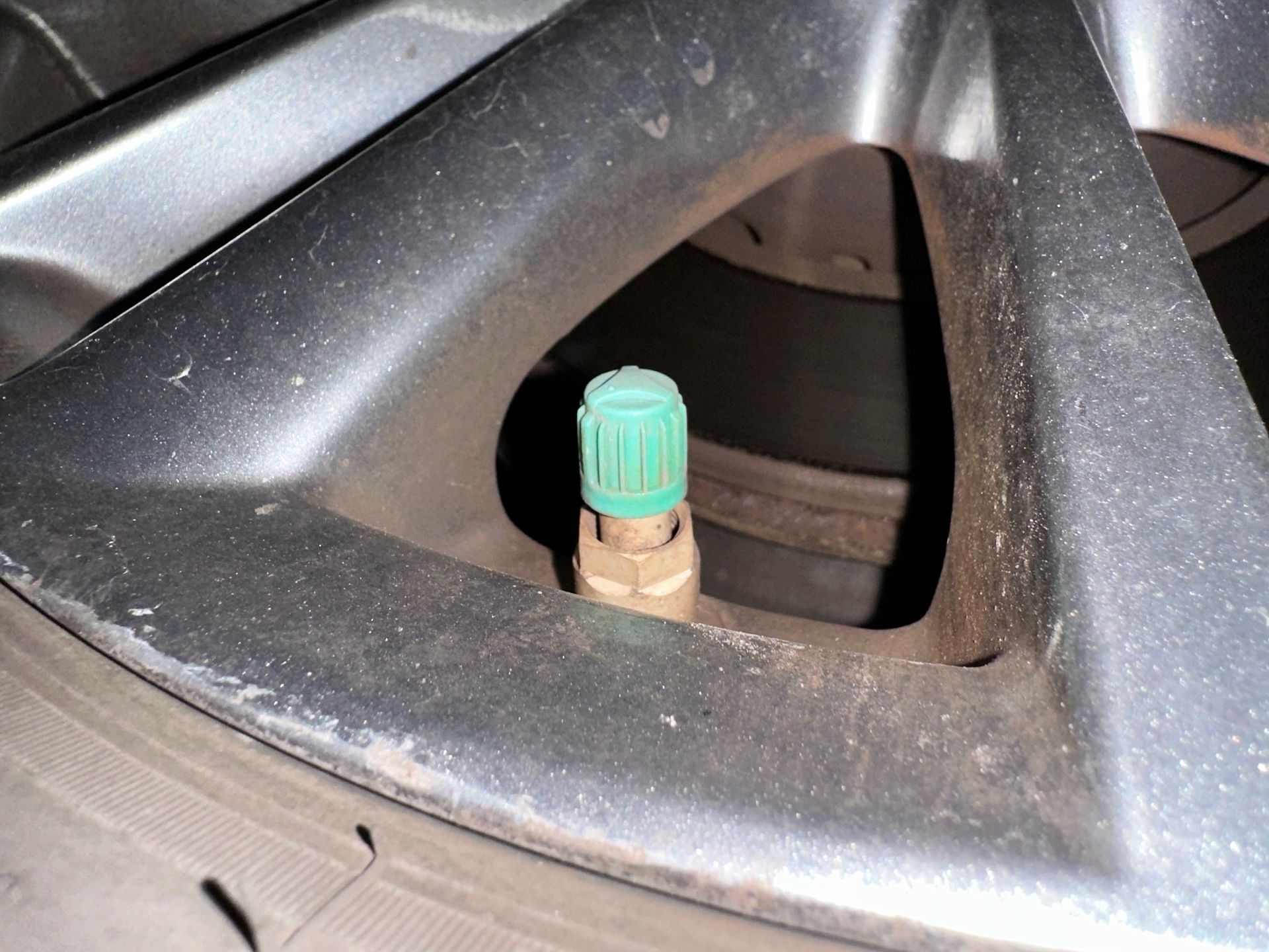 Wheel valve stem with green cap.