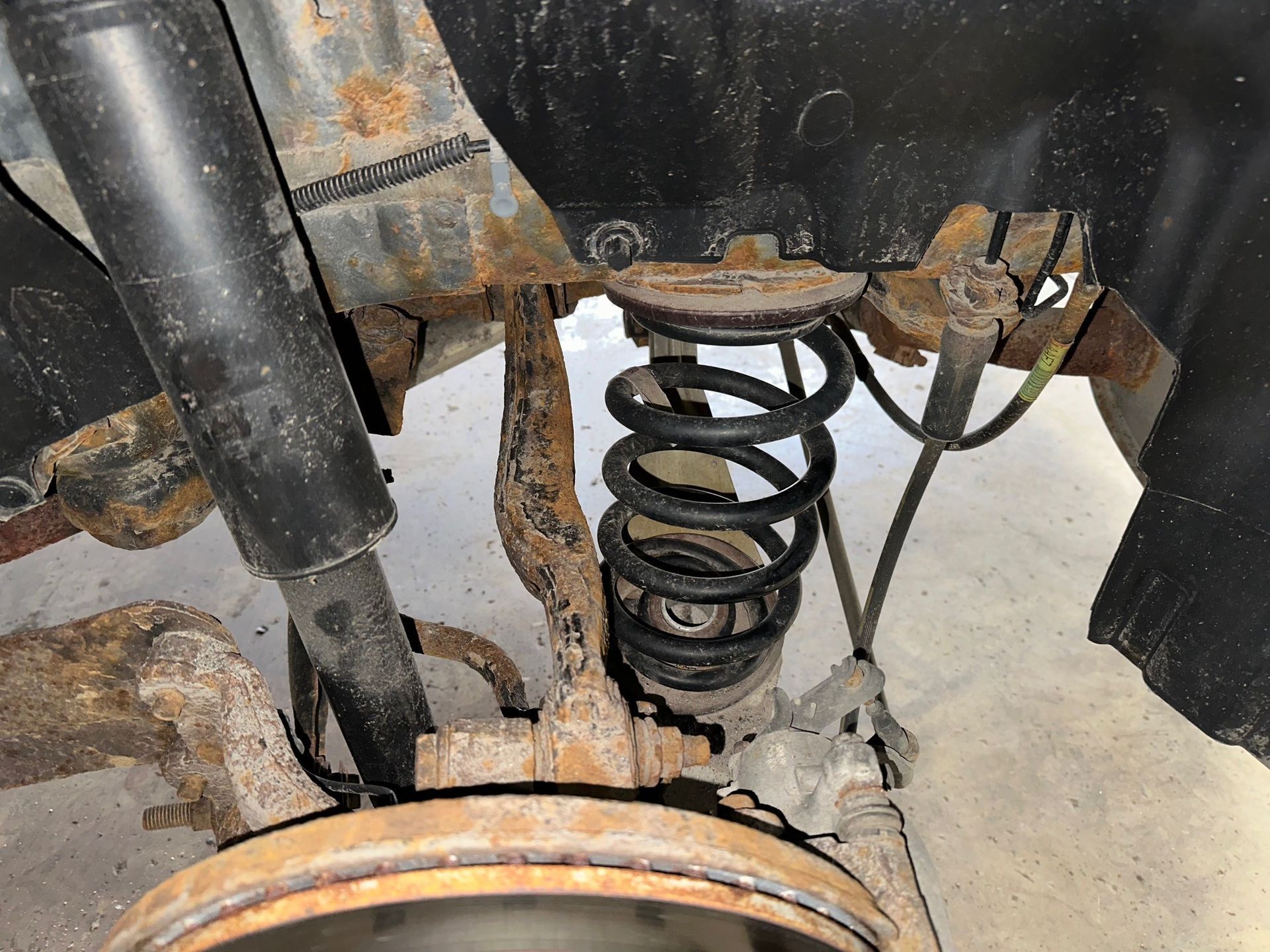 A black coild spring and shock on a vehicle. | Lou's Car Care Center, Inc.