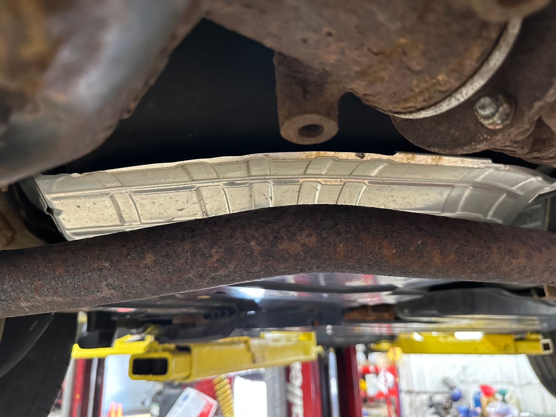A close up of the underside of a car on a lift. | Lou's Car Care Center