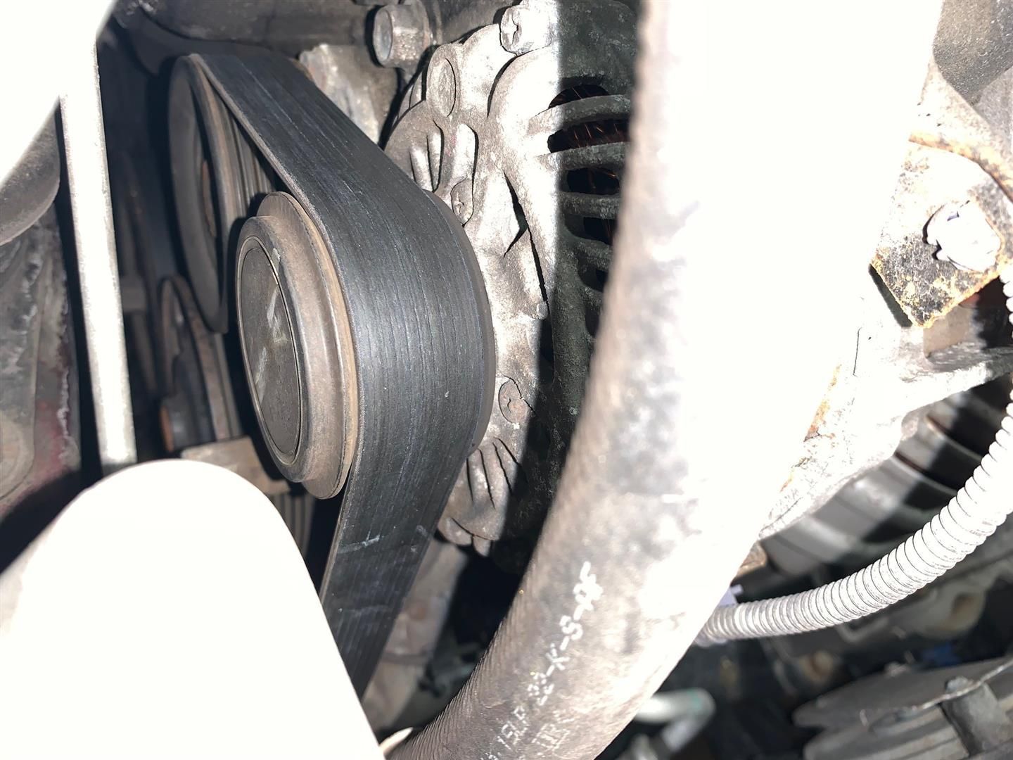 A close up of a belt on a car engine | Lou's Car Care Center Inc.