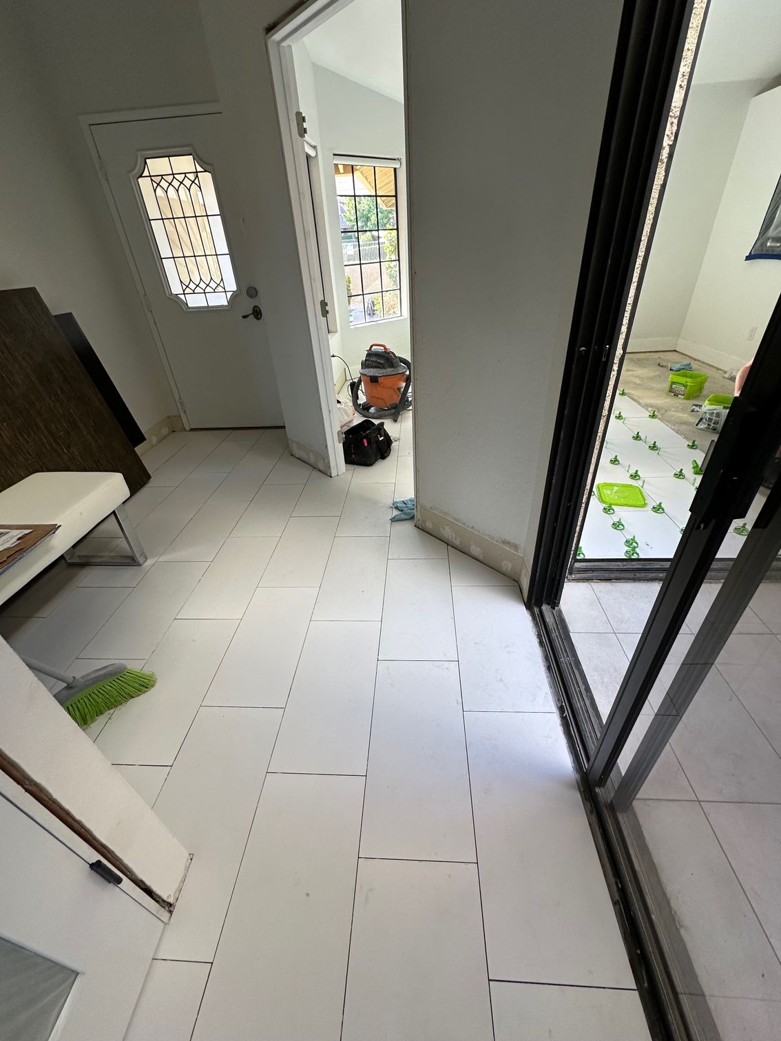White tile flooring being installed in a doorway
