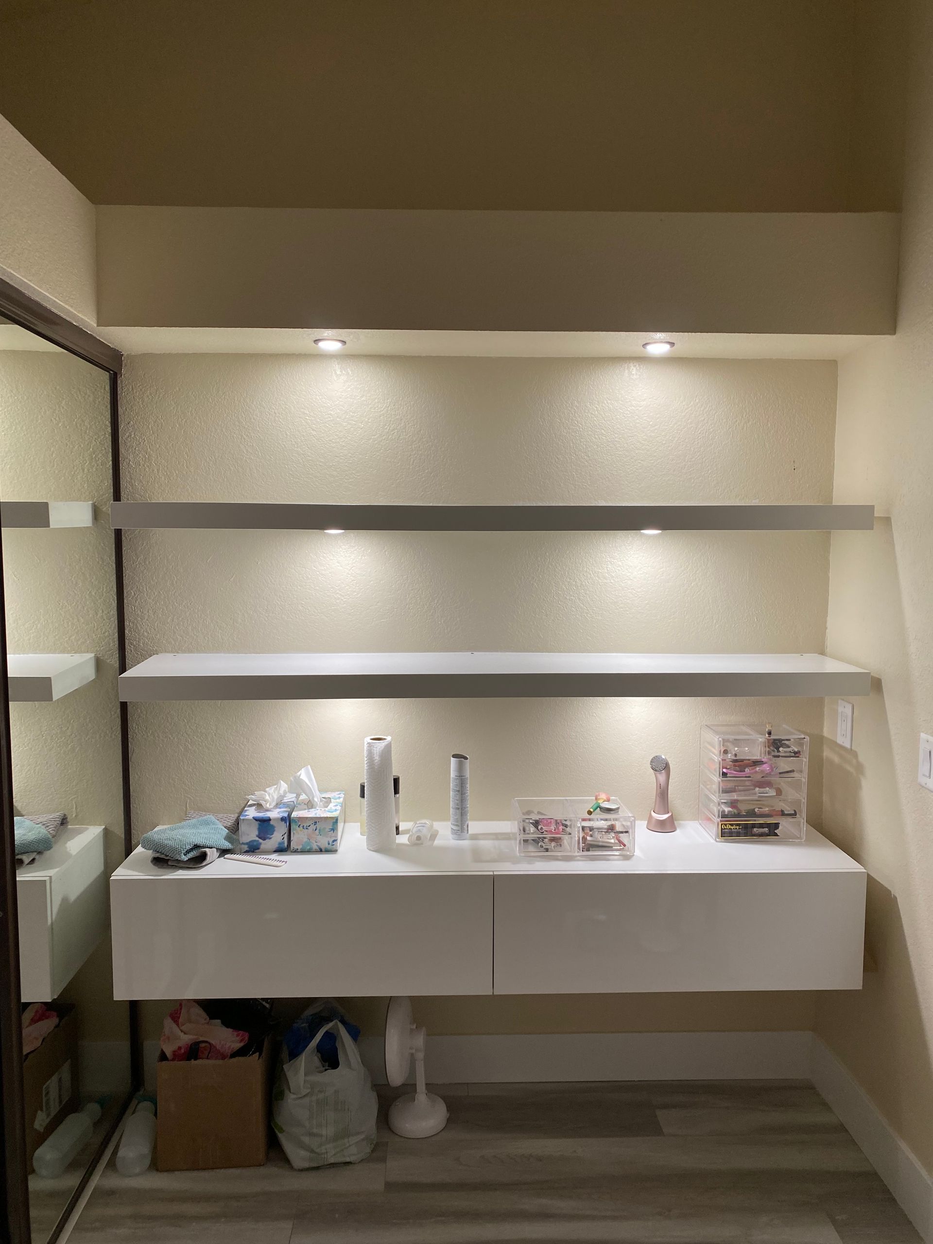 White shelves and a floating cabinet with items
