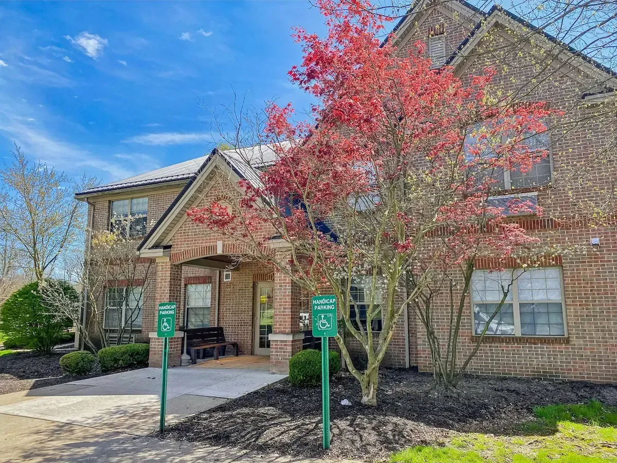 A large brick house with a tree in front of it.