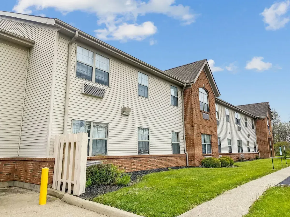 A large apartment building with a walkway leading to it.