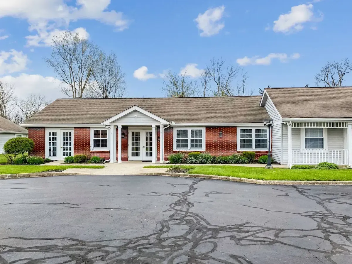 A large red brick house with a white porch is for sale.