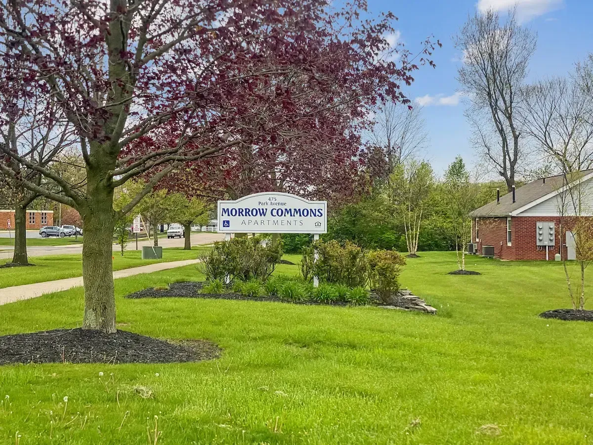 A large lush green field with a sign in the middle of it.