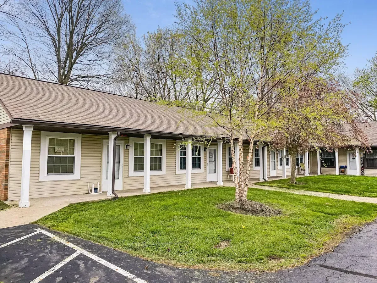 A row of houses with a lot of windows and trees in front of them.