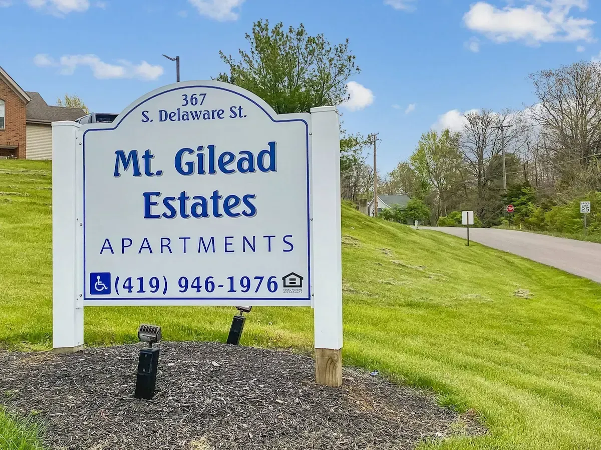 A white sign for mt. gilead estates apartments