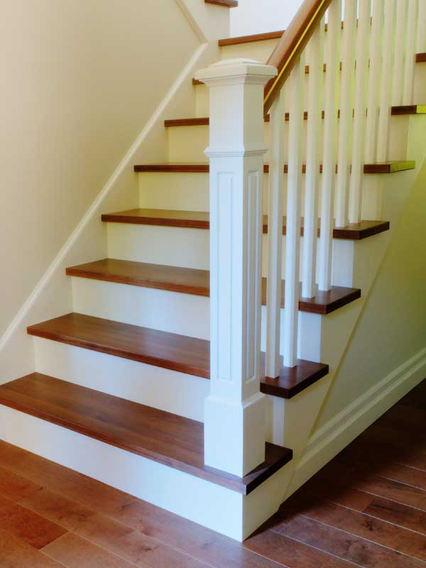 Wooden staircase with white risers, brown steps, and white balustrade.