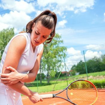 a person is holding their arm in pain from Sports Injury