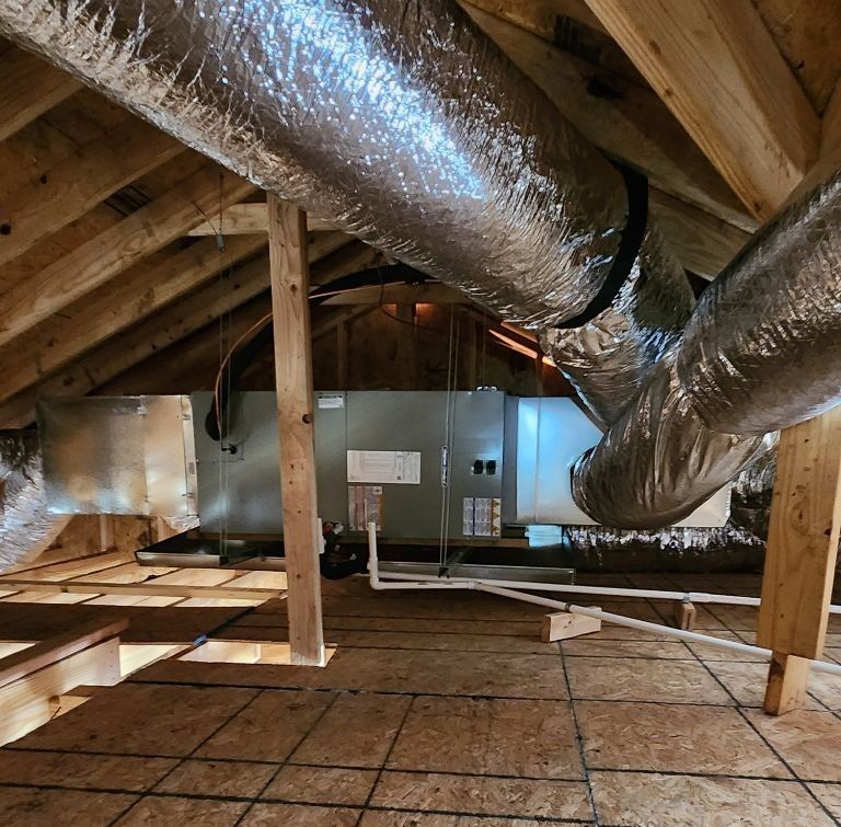An attic with a lot of ducts and pipes