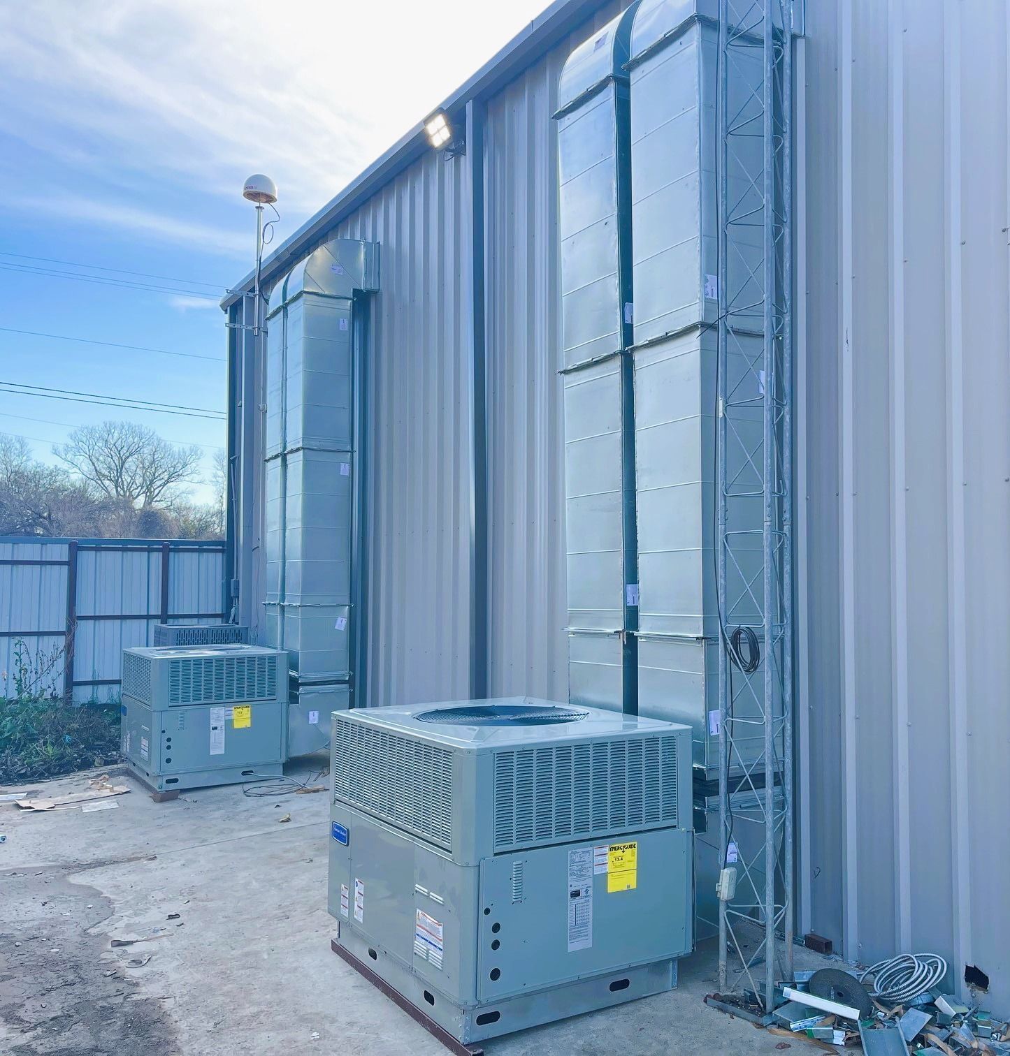 Two air conditioners are sitting outside of a building.