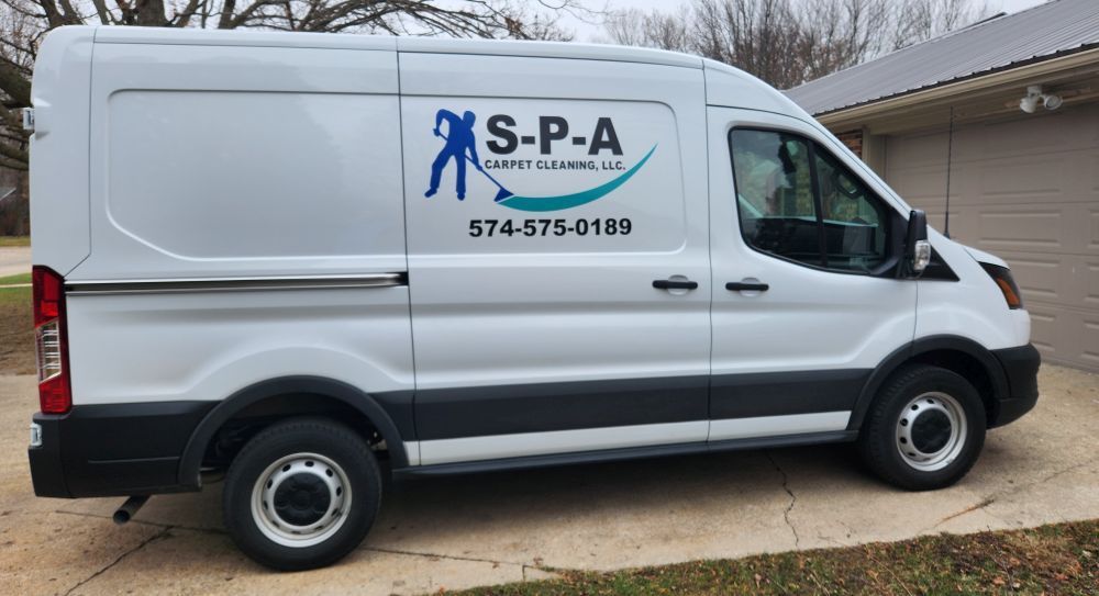 A white S-P-A Carpet Cleaning van parked in a driveway.