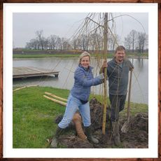 Een man en een vrouw staan ​​naast een boom