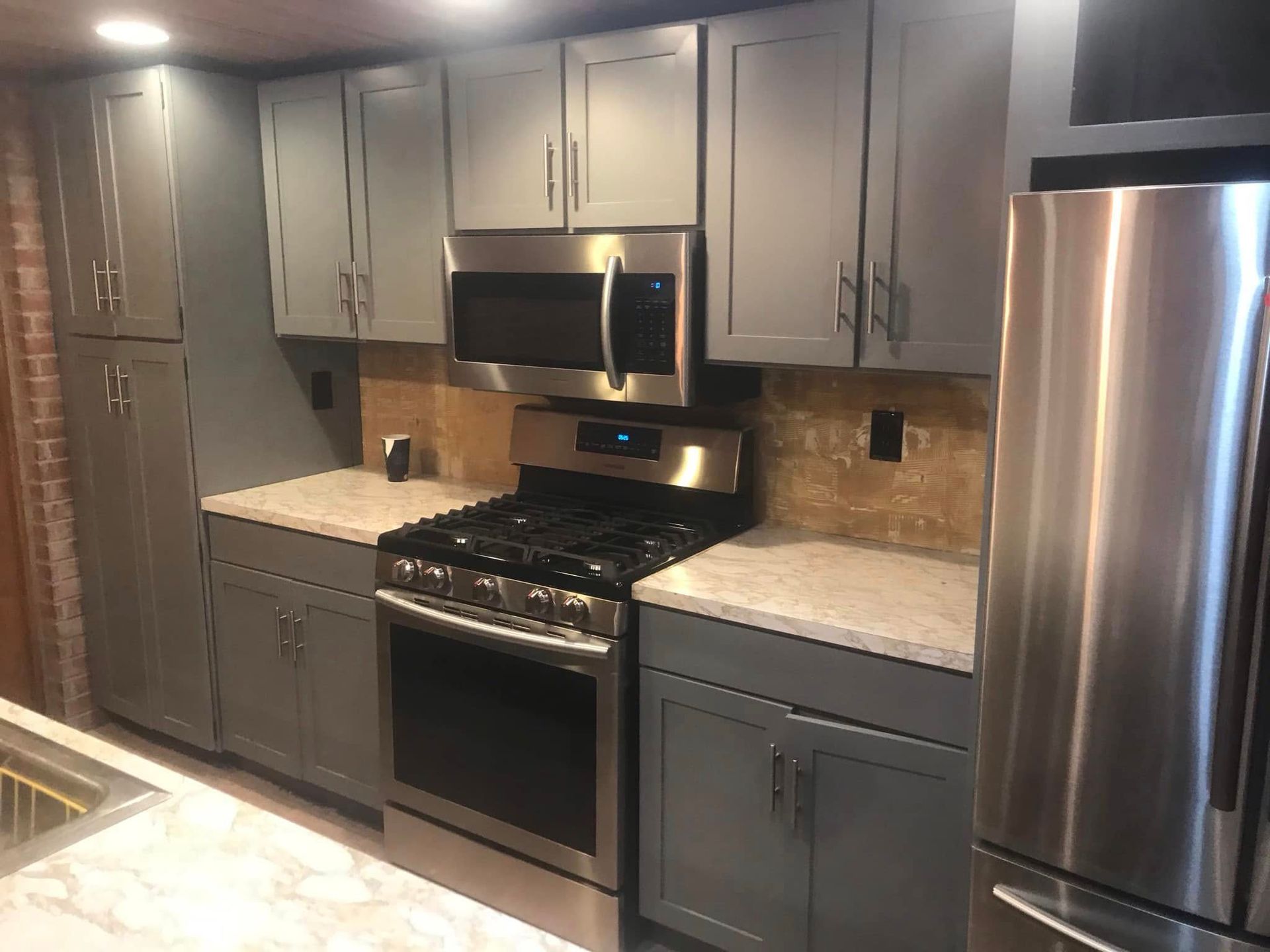 Modern kitchen with gray cabinets, stainless steel appliances, and granite countertops. Modern kitchen with gray cabinets, stainless steel appliances, and granite countertops.