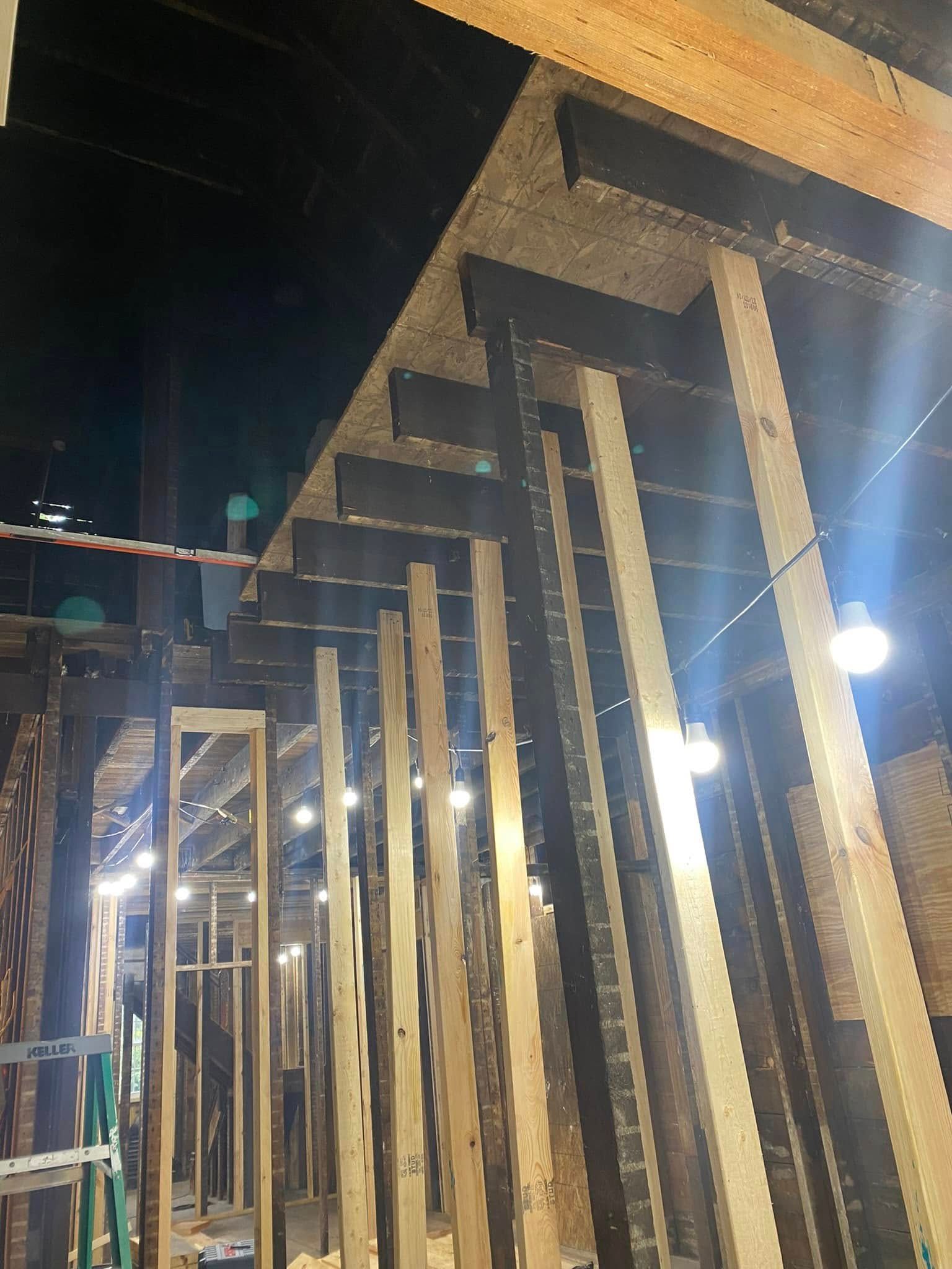 Row of illuminated wooden frames under construction at night, viewed from below. Row of illuminated wooden frames under construction at night, viewed from below.