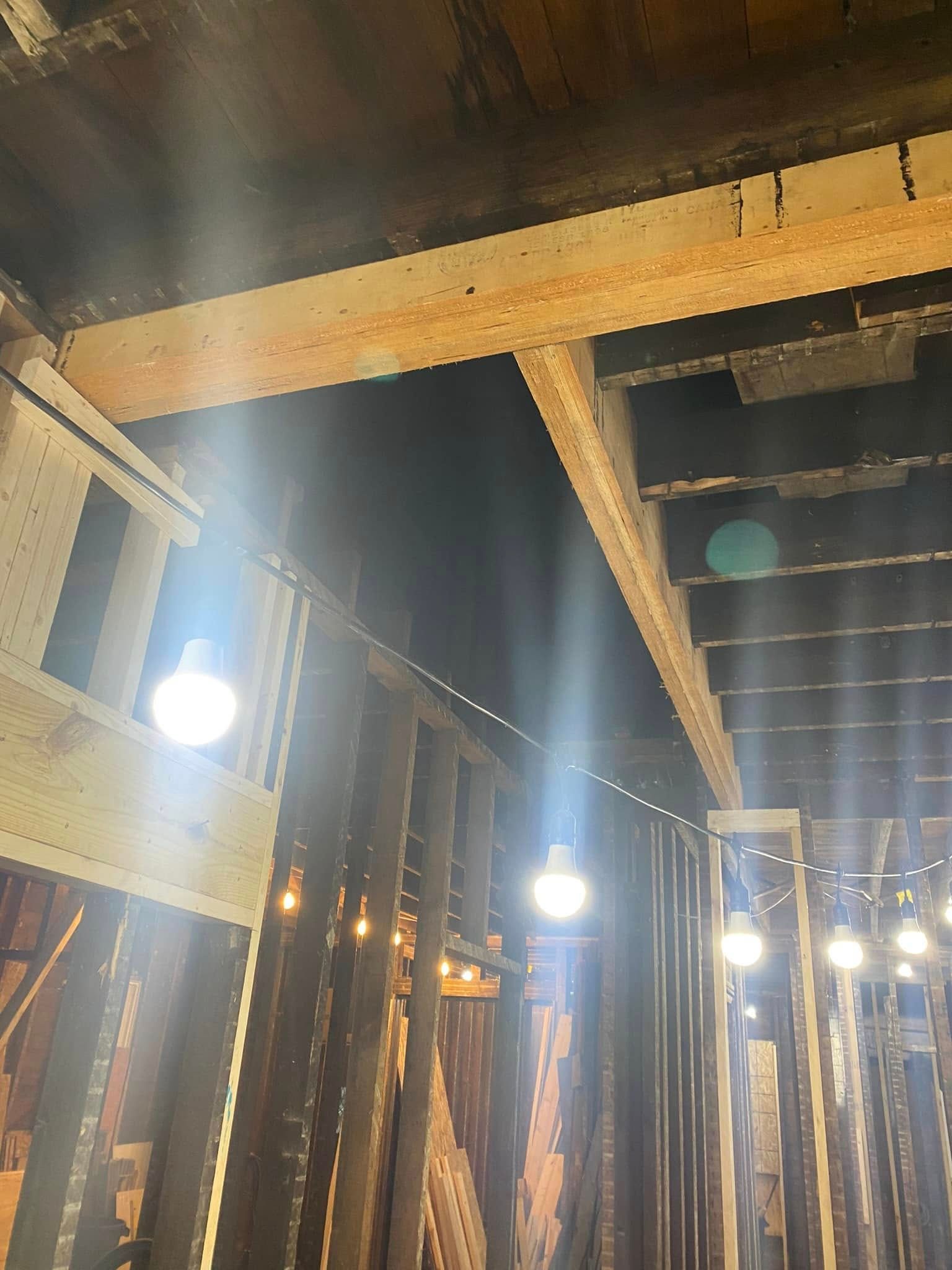 Indoor wooden beams and hanging lights in a rustic interior with high ceiling Indoor wooden beams and hanging lights in a rustic interior with high ceiling