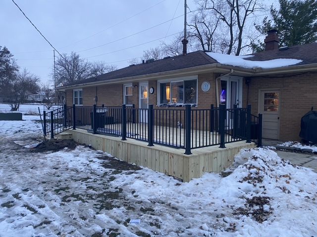 Blue single-story house with white trim and wheelchair ramp on a green lawn under a clear sky Blue single-story house with white trim and wheelchair ramp on a green lawn under a clear sky