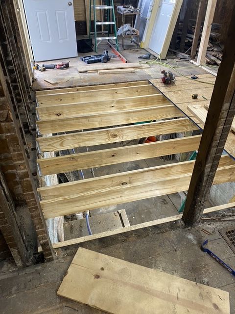 Partially built roof truss with Tyvek wrap and a wood plank on a house under construction Partially built roof truss with Tyvek wrap and a wood plank on a house under construction