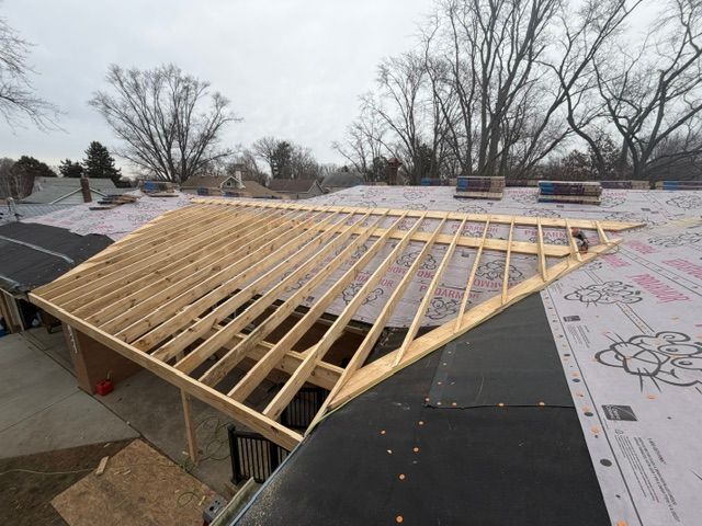 Front porch under construction with ladders, tools, and exposed wooden roof framing Front porch under construction with ladders, tools, and exposed wooden roof framing