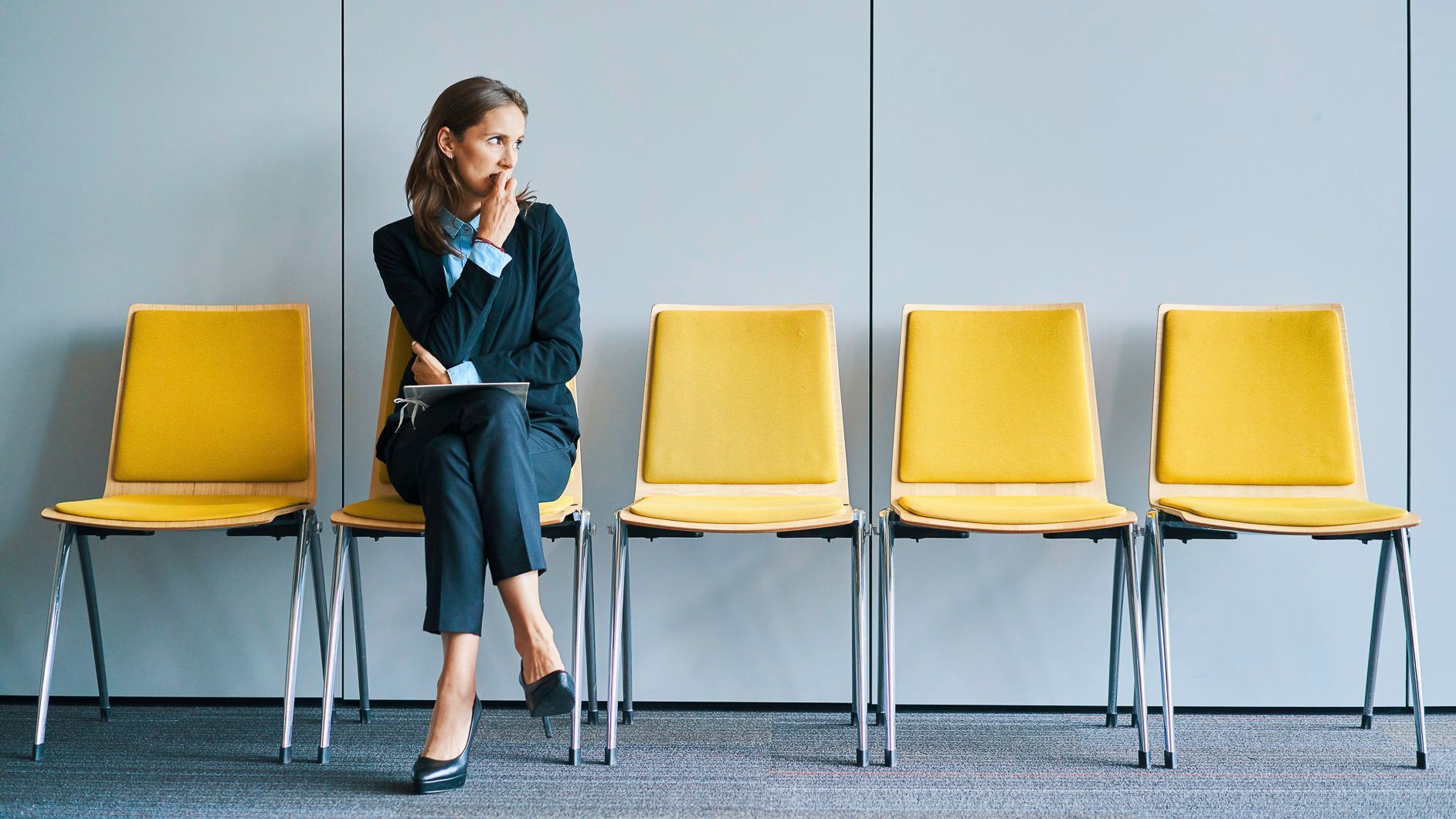 a woman sitting in an empty row of chairs