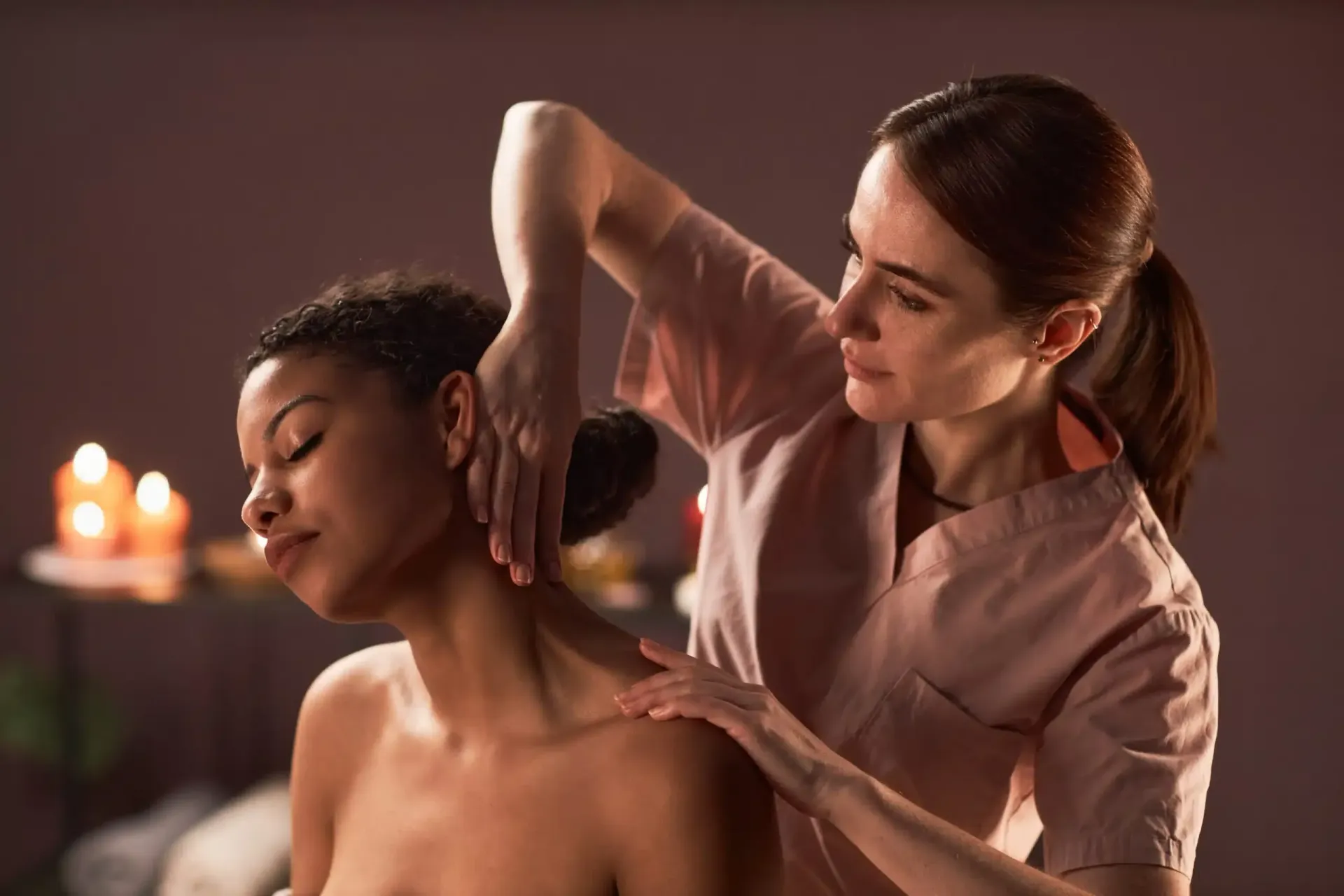 Man lying on a treatment table with electrodes on chest while a clinician holds a device nearby