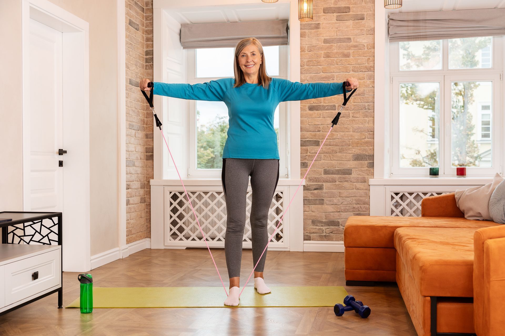Woman exercising with resistance bands in a bright living room