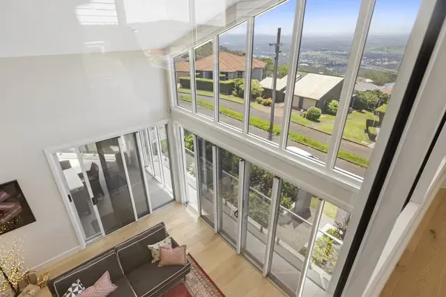 Modern living room with tall glass windows overlooking a bright outdoor view