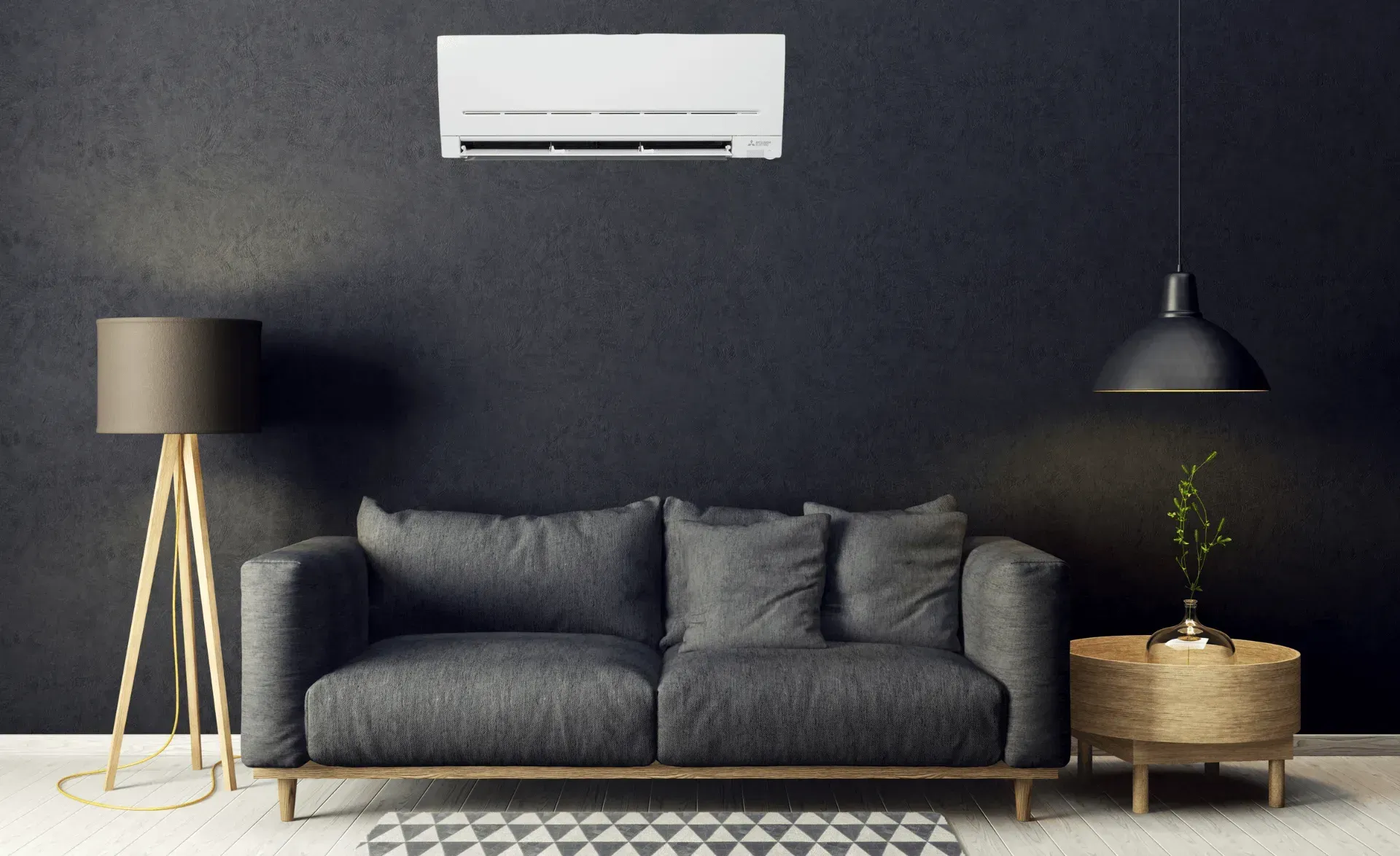 Modern living room with dark sofa, floor lamp, hanging pendant, side table, and wall-mounted air conditioner