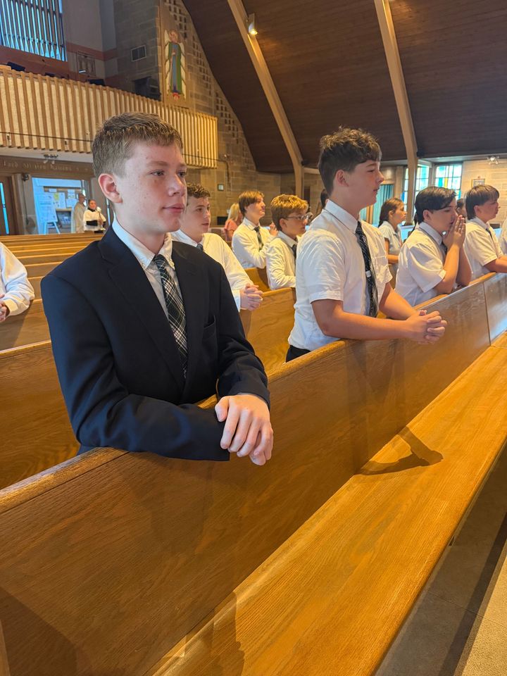 a group of children are praying in a church with a piano in the background .