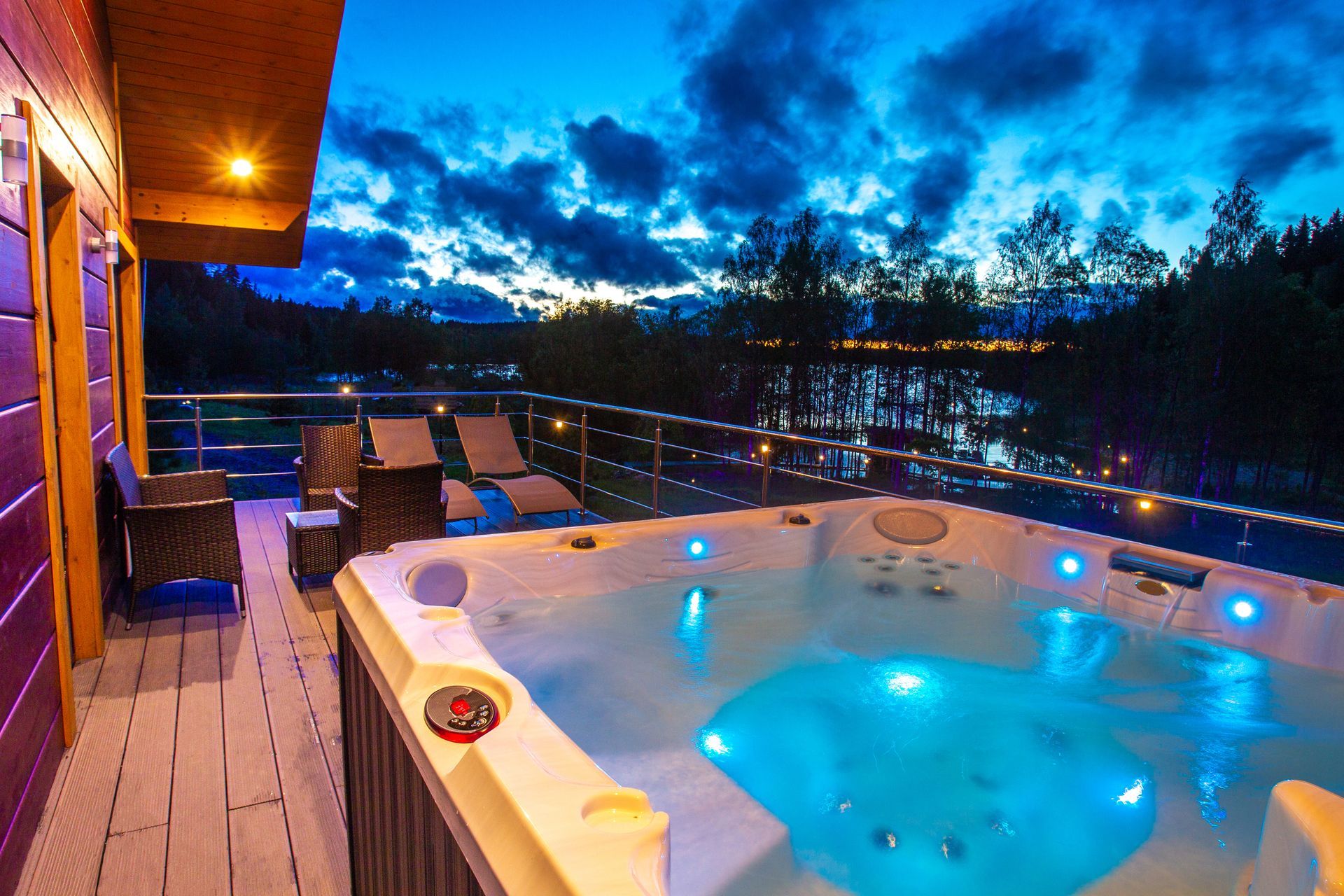 Un bain à remous sur un balcon donnant sur un lac la nuit