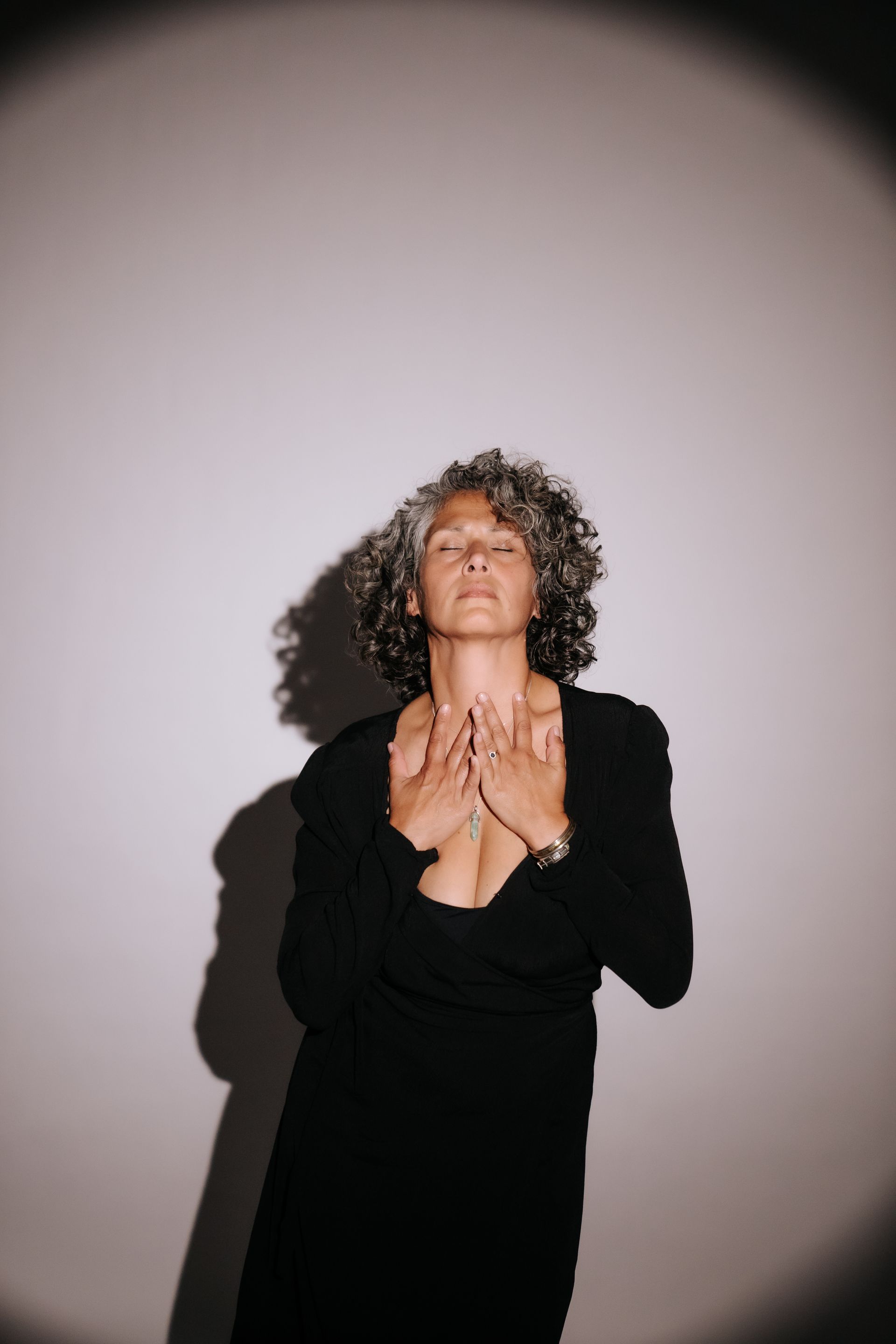 Vrouw met handen op haar hart – moment van overgave en verbinding.