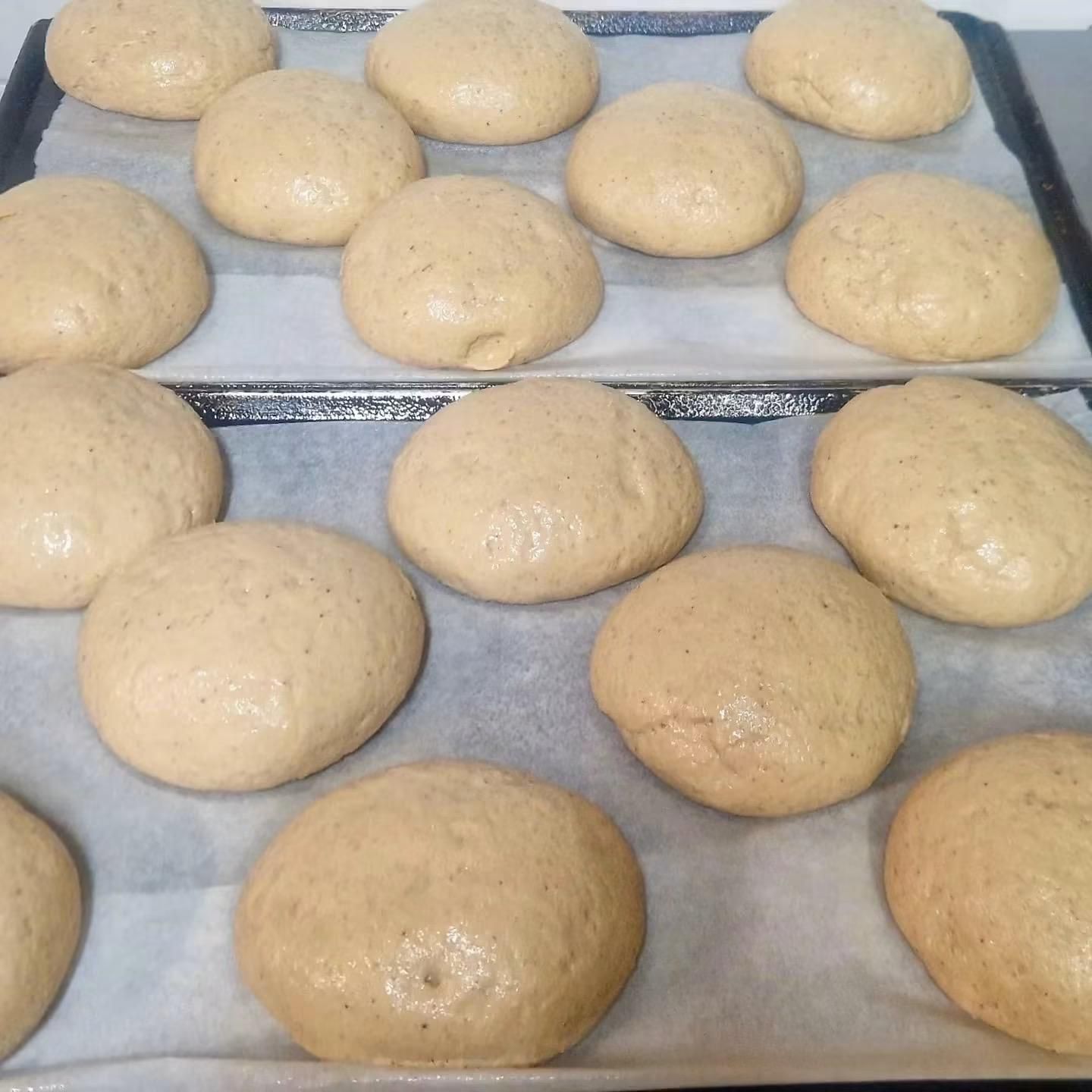 Panini appena sfornati che si raffreddano su vassoi foderati di carta da forno.