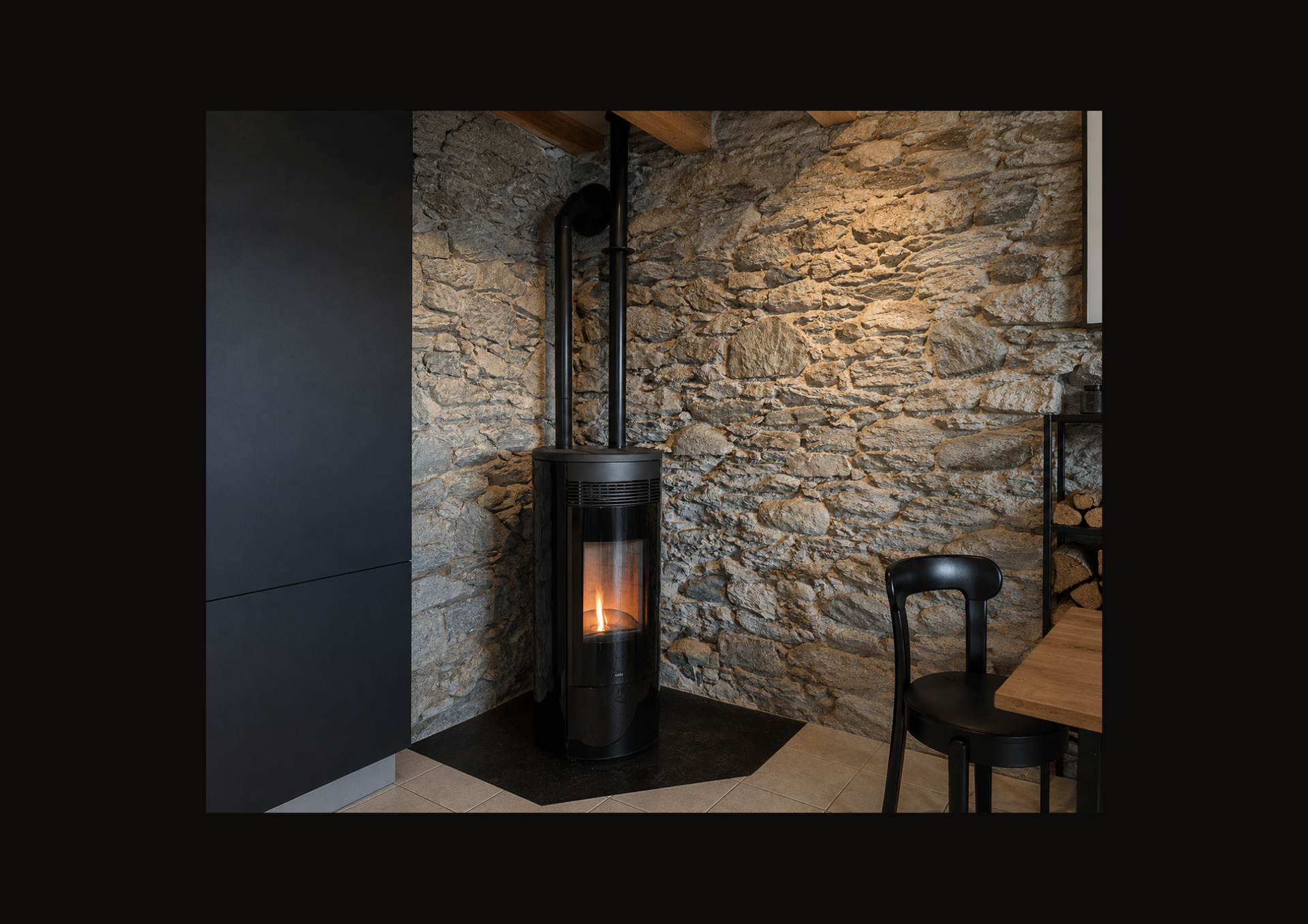 Coin de pièce moderne avec un poêle à bois noir adossé à un mur en pierre, le feu incandescent visible à l'intérieur.