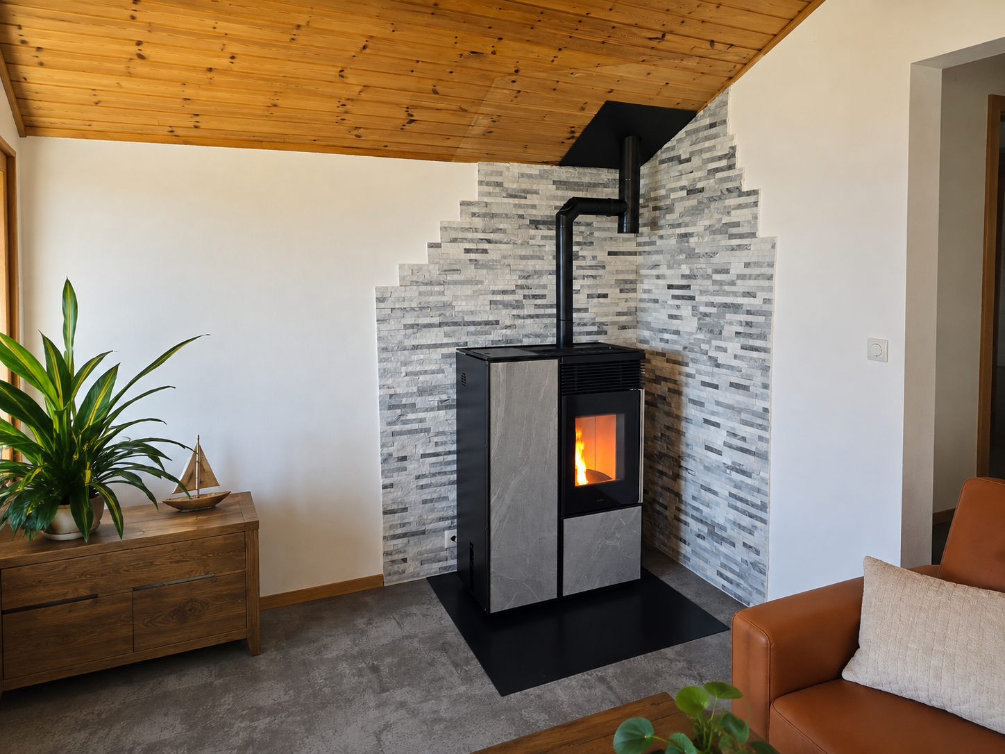 Salon moderne avec poêle à bois, mur en pierre, plafond mansardé et plante d'intérieur