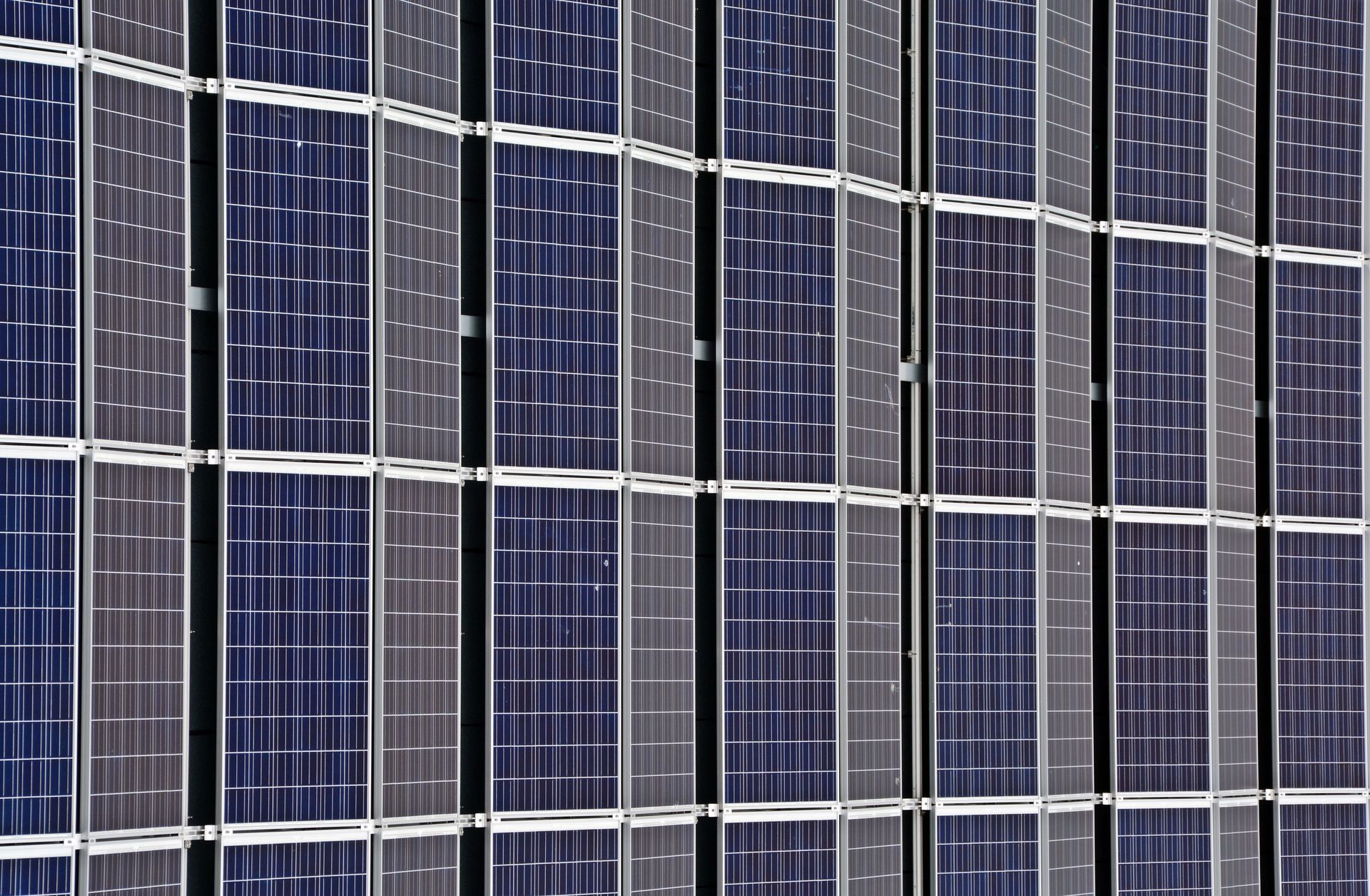 Gros plan de rangées de panneaux solaires bleu foncé avec des lignes de quadrillage blanches