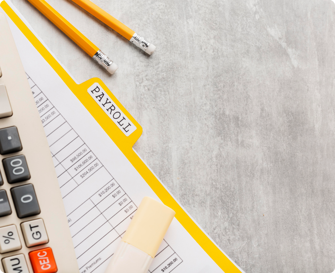 A calculator , pencils , and a payroll form are on a table.
