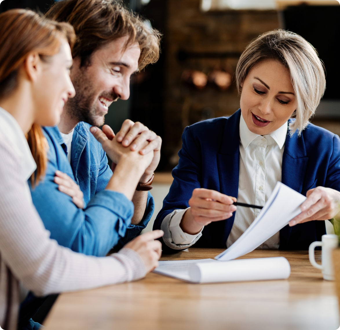 A group of people are sitting at a table looking at a piece of paper.