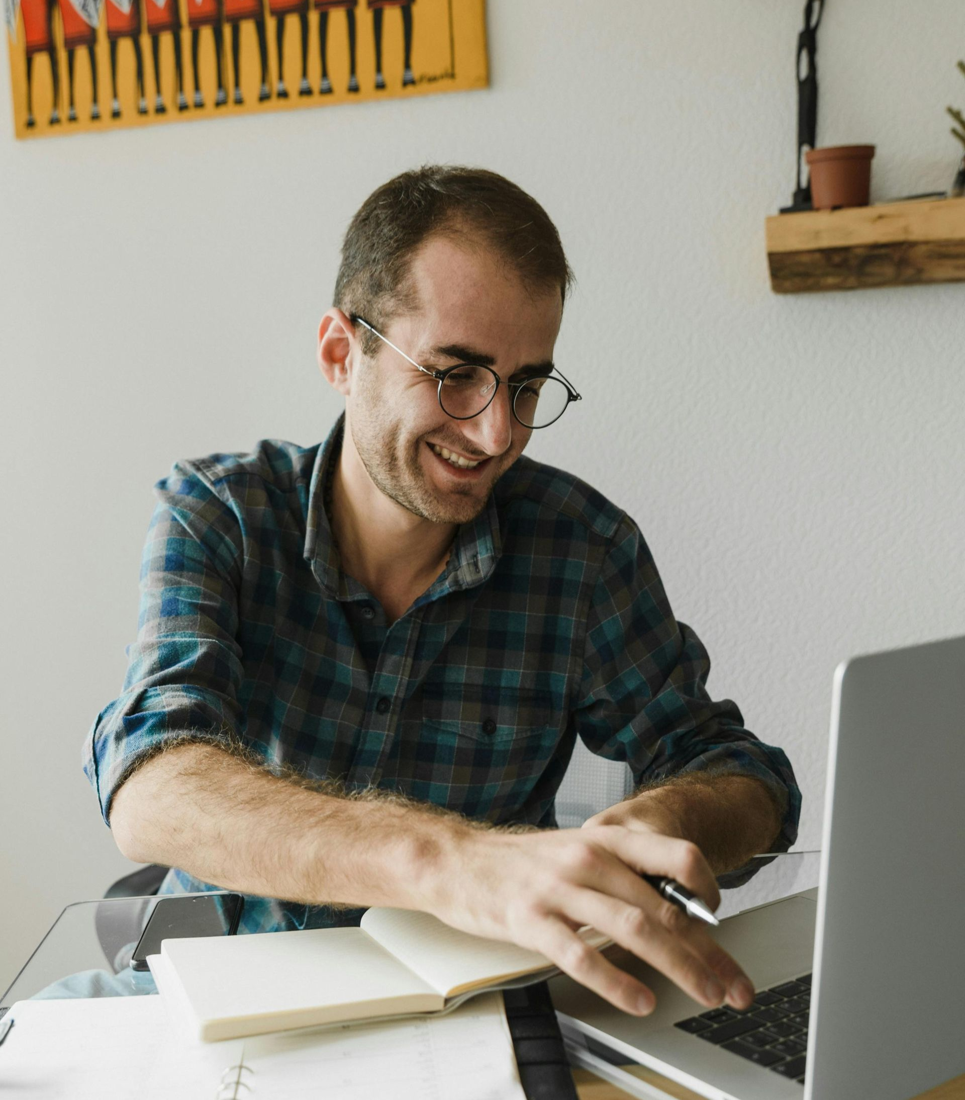 Couple reviewing documents with a professional at a table, smiling. Laptop visible.