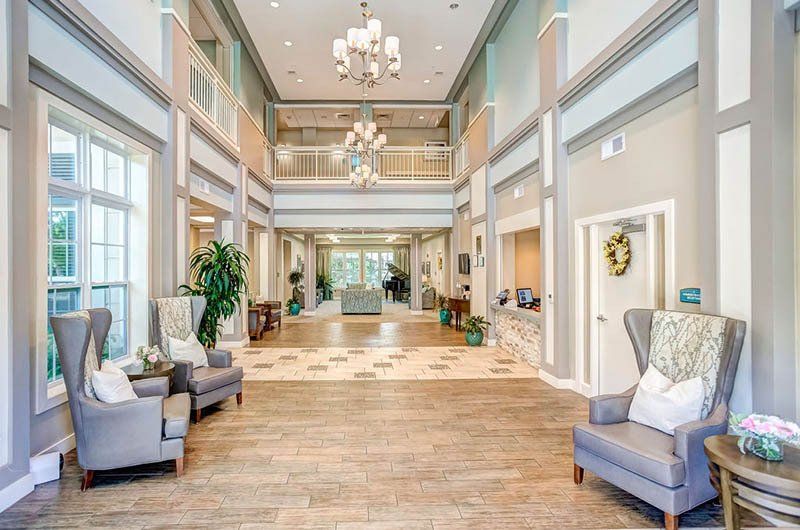 A large lobby with chairs , tables and a chandelier.