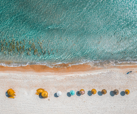 An aerial view of a beach with umbrellas and people.