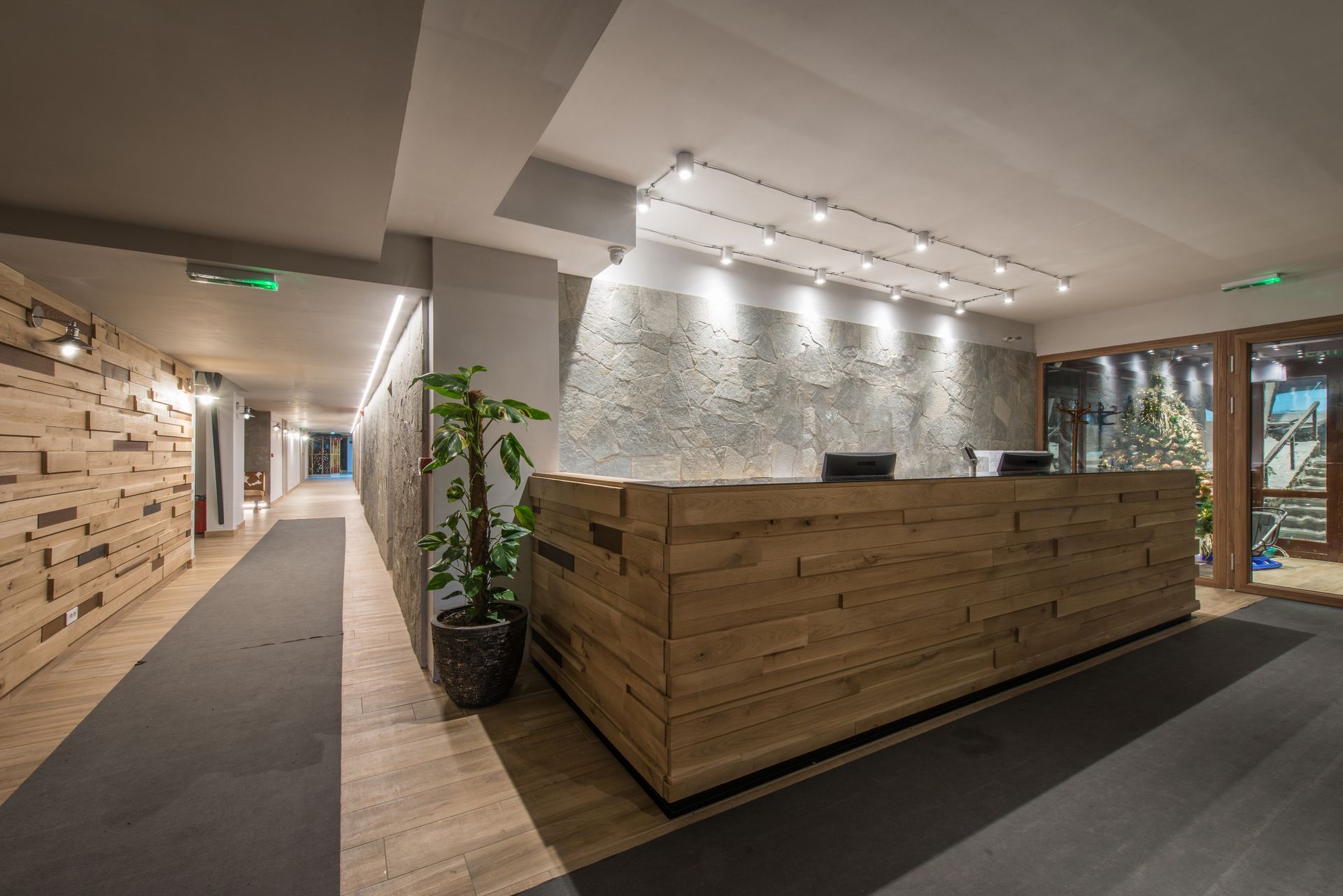 a long hallway with a wooden reception desk in the middle of it .