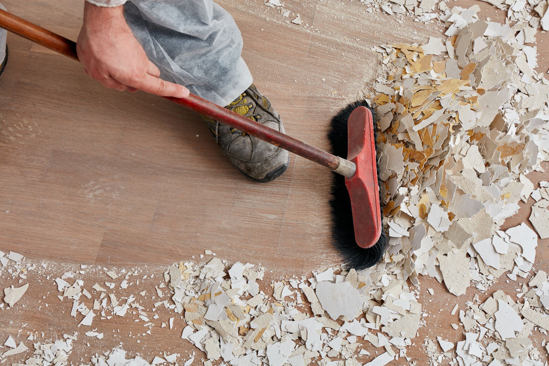 a person is sweeping the floor with a broom .