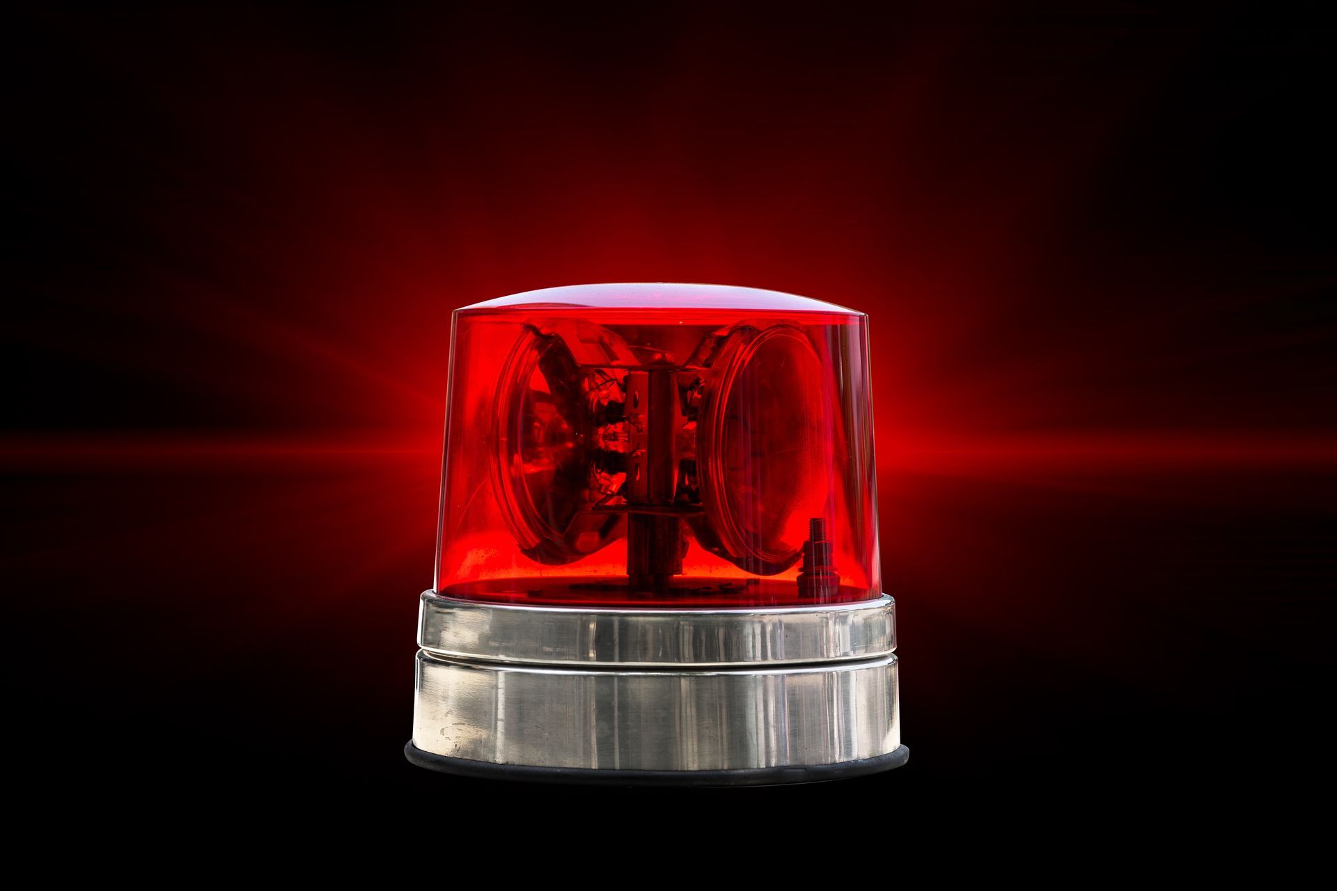 a red emergency light is lit up on a red background .