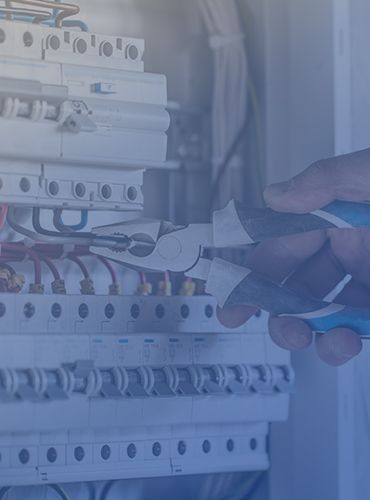 a person is working on an electrical box with a pair of pliers .