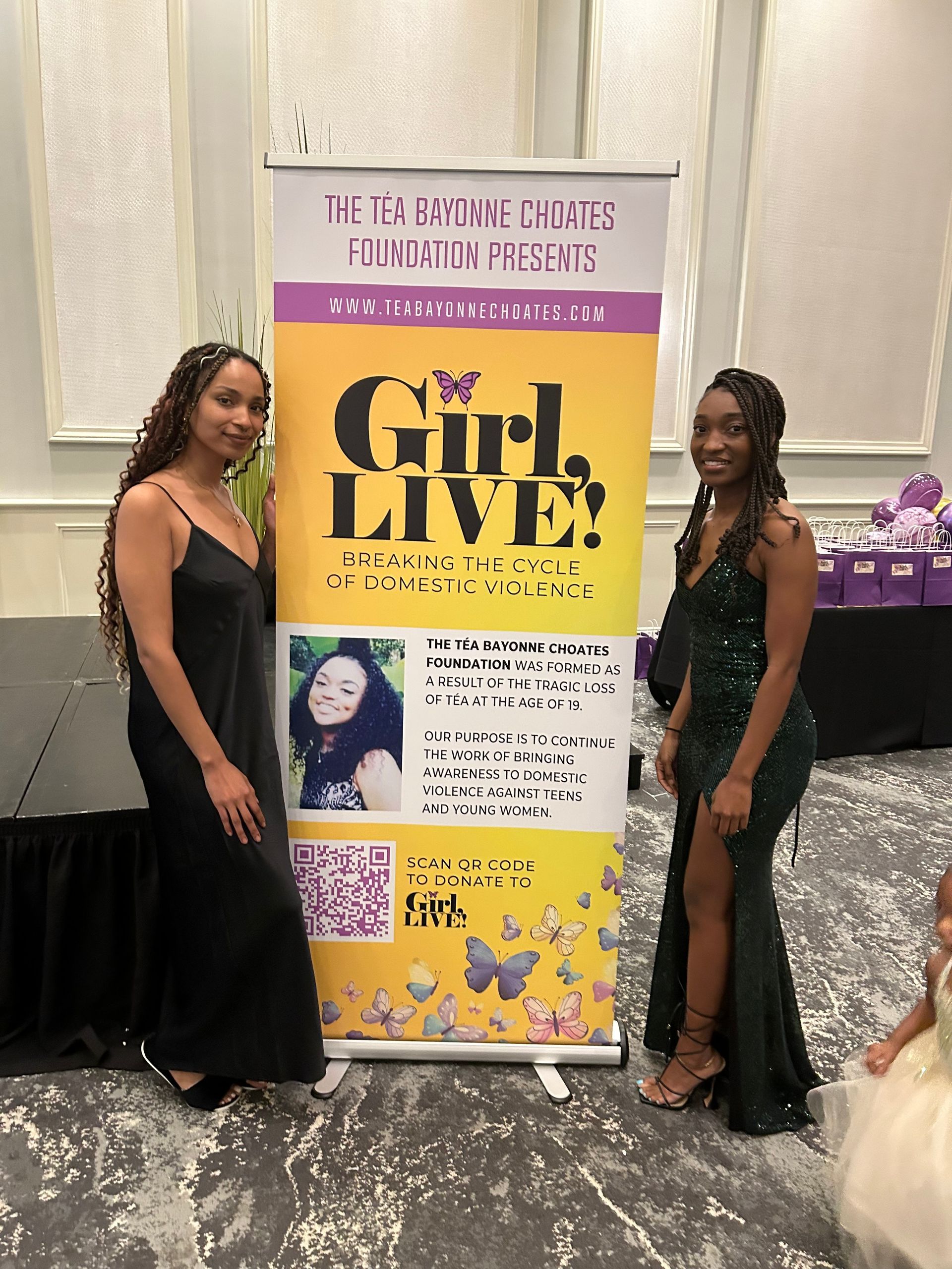 Two women standing next to a sign that says girl live