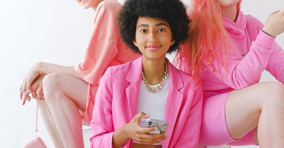A woman in a pink jacket is sitting next to two other women.